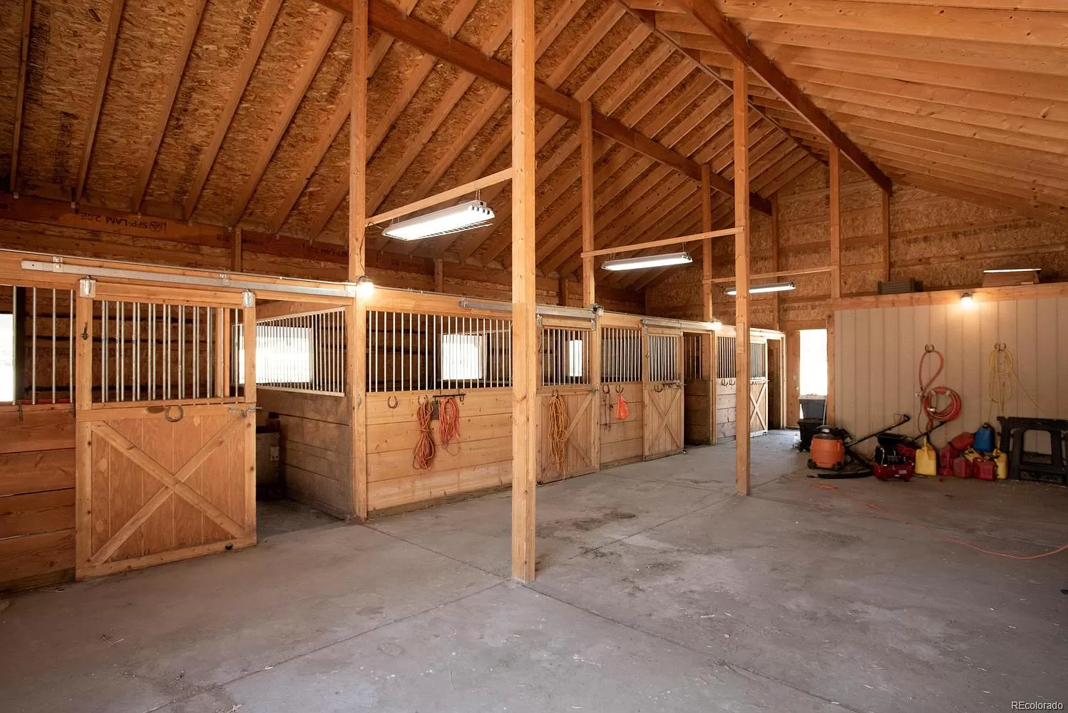 A barn with many stalls and horses inside of it