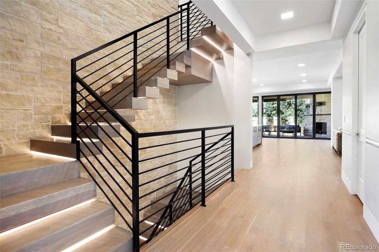 A staircase with metal railing and wooden steps.