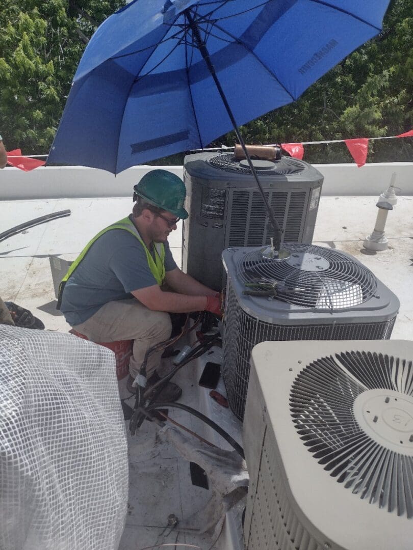 worker repairing fan with blue umbrella