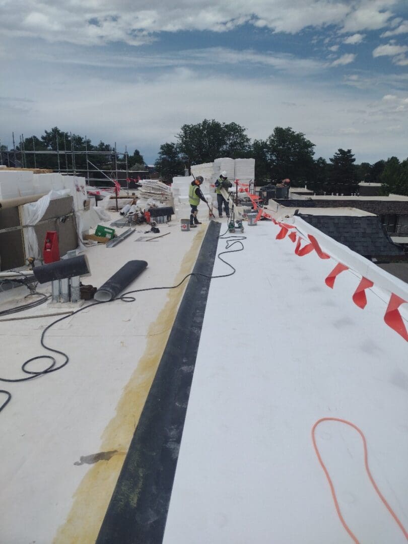 white rooftop with construction workers and red flags
